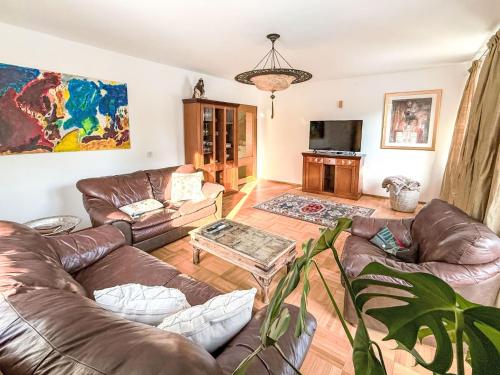 a living room with leather couches and a flat screen tv at Villa Acereto by Interhome in Nassereith