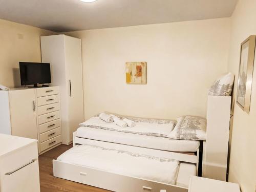 a small bedroom with two beds and a tv at Apartment Studio Turmalin by Interhome in Leukerbad