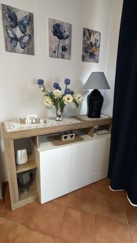 a table with a vase of flowers on it at Casa Vacanze Palidoro Il Plumbaco in Palidoro