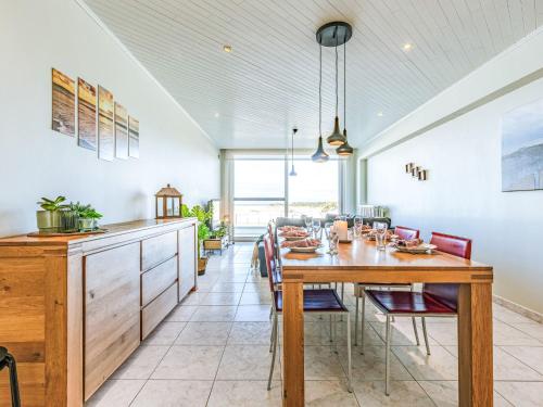 a kitchen and dining room with a wooden table and chairs at Apartment Trondjhem with seaview by Interhome in Bruges