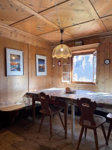 a dining room with a large wooden table and chairs at Vicinanza d'Andraz in Andraz