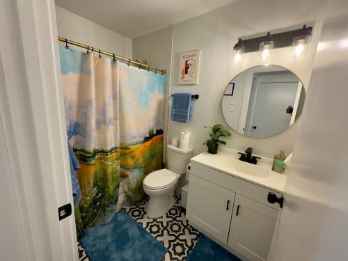 a bathroom with a toilet and a sink and a mirror at 5 Star Stay Large Remodeled Modern 4BR Near UNT and TWU Sleeps 10 in Denton