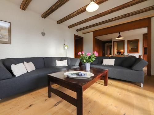 a living room with two blue couches and a coffee table at Apartment Regina D1 by Interhome in Arveyes