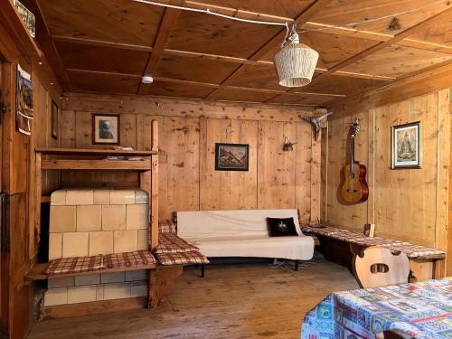 a room with a bed and a guitar in it at Vicinanza d'Andraz in Andraz
