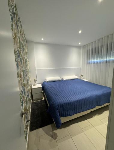 a bedroom with a blue bed and a window at Albir Beach & Sea Apt in Albir