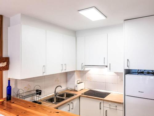 a kitchen with white cabinets and a sink at Apartment Salina by Interhome in Llança
