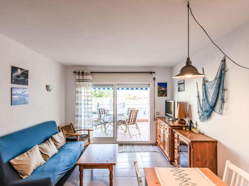 a living room with a blue couch and a table at Apartment Salina by Interhome in Llança