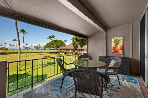 a balcony with a table and chairs and a view of the golf course at Maui Eldorado H202 in Kaanapali