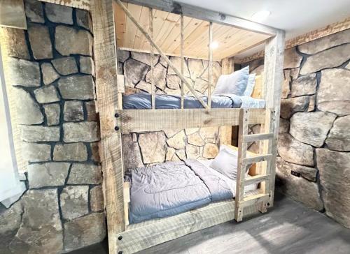 a room with two bunk beds in a stone wall at cozy cabin in Dalton