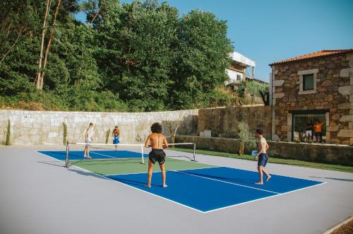a group of people playing tennis on a tennis court at Sandoco - Golf - Pickleball - Beach Volleyball & Pool - All Exclusive in Ponte de Lima