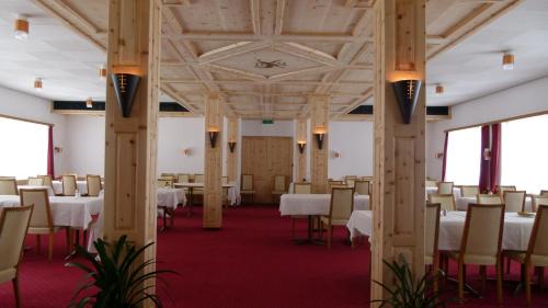 ein Esszimmer mit weißen Tischen und Stühlen in der Unterkunft Ferienwohnung Grischuna in Bivio