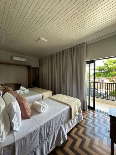 a hotel room with two beds and a balcony at Casa Prado in Prado