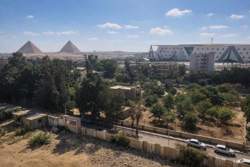 a view of the pyramids from the city of pyramids at 3 Pyramids Grand Egyptian Museum View in Cairo