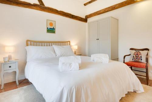 a bedroom with a white bed and a chair at 3 Bed in Ridlington oc-2253 in Walcott