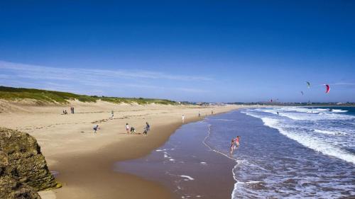 a group of people on a beach flying kites at Relaxing Getaway in South Shields! in Jarrow