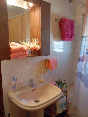ein Badezimmer mit Waschbecken und Spiegel in der Unterkunft Caelum in Riumar