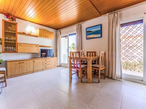 a kitchen with a wooden ceiling and a table and chairs at Apartment Delfines by Interhome in Cambrils
