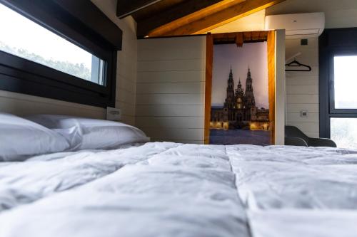 a bedroom with a large white bed and a window at Vencello Estelar Compostela in Santiago de Compostela