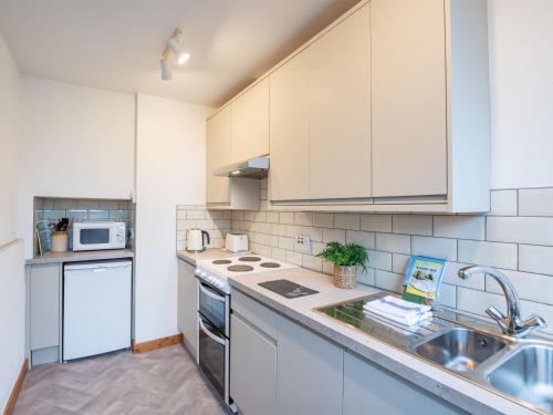 a kitchen with white cabinets and a sink at Apartment Pond View on Aigas Golf Course by Interhome in Beauly