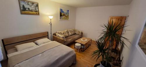 a small bedroom with a bed and a couch at Apartment KRIVÁŇ in Vyšné Hágy