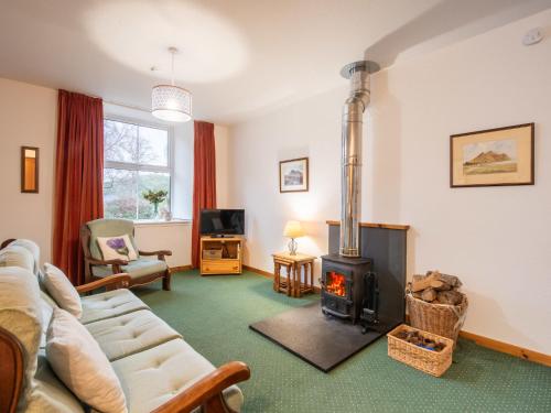a living room with a couch and a wood stove at Apartment Old Stable on Aigas Golf Course by Interhome in Beauly