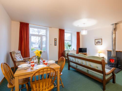 a living room with a table and chairs and a couch at Apartment Old Stable on Aigas Golf Course by Interhome in Beauly