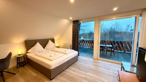 a bedroom with a bed and a balcony at Bootshaus Hamm in Hamm