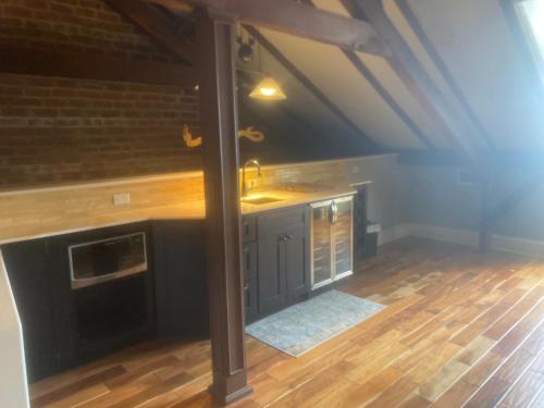 an attic kitchen with wooden floors and a beam at NOLA Condos in New Orleans