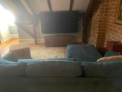 a living room with a blue couch and a flat screen tv at NOLA Condos in New Orleans