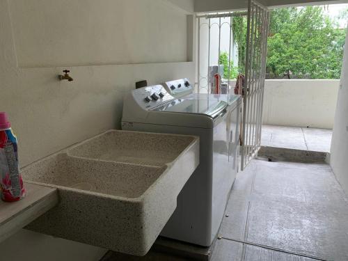 a kitchen with a sink and a window and a tub at LÁZARO D primer piso in Monterrey