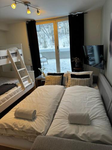 two large beds in a room with a window at Resort by the Lake - Pool & Sauna in Vossevangen