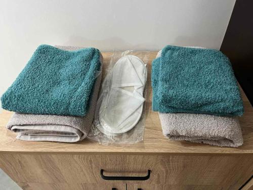 two towels and a pair of shoes on a wooden shelf at Бунгала ЛАГО in Gabrene