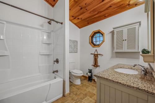 a bathroom with a tub and a sink and a toilet at River Time Cabin - Riverfront, Hot Tub, Screen Porch, Fishing, Games, View, 3 King Beds in Berkeley Springs