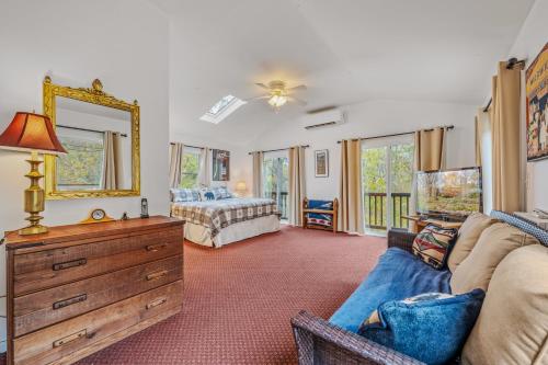 a living room with a couch and a bed and a mirror at River Time Cabin - Riverfront, Hot Tub, Screen Porch, Fishing, Games, View, 3 King Beds in Berkeley Springs