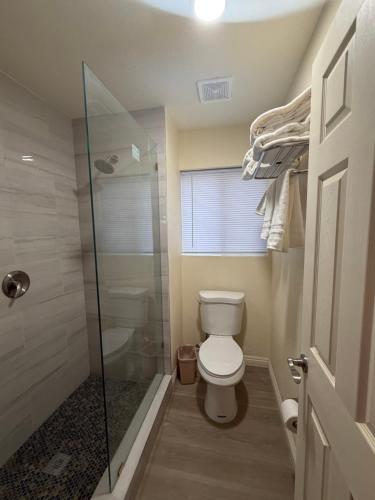 a bathroom with a toilet and a glass shower at RELAX hotel and spa in Desert Hot Springs