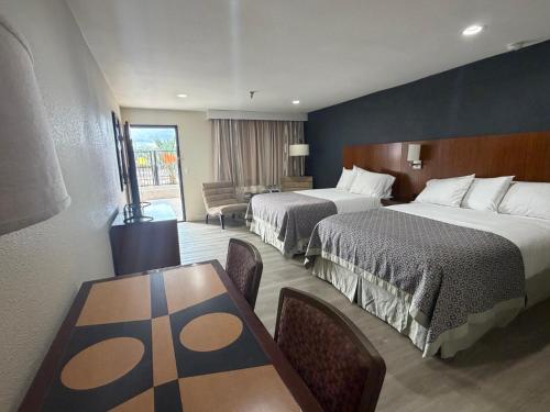 a hotel room with two beds and a table at RELAX hotel and spa in Desert Hot Springs