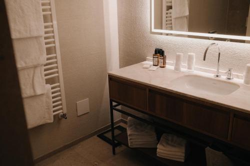 a bathroom with a sink and a mirror at Hotel Austria Lech in Lech am Arlberg