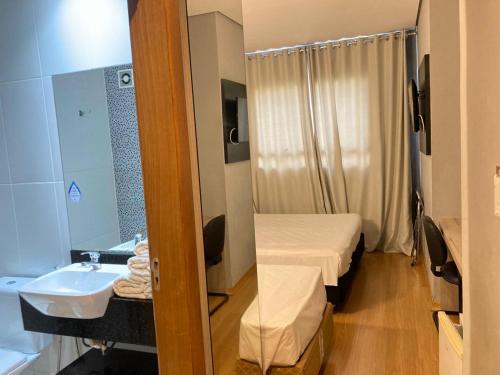 a hospital room with a bed and a sink at Stop Inn Plus Pampulha in Belo Horizonte