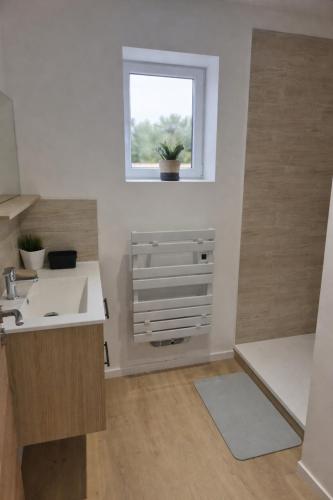 a bathroom with a sink and a window at Gîte de l'Avenue Verte in Neufchâtel-en-Bray