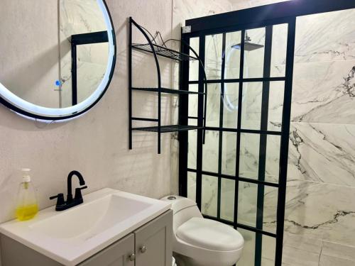 a bathroom with a sink and a toilet and a mirror at 6 VENATOR House Boutique in León