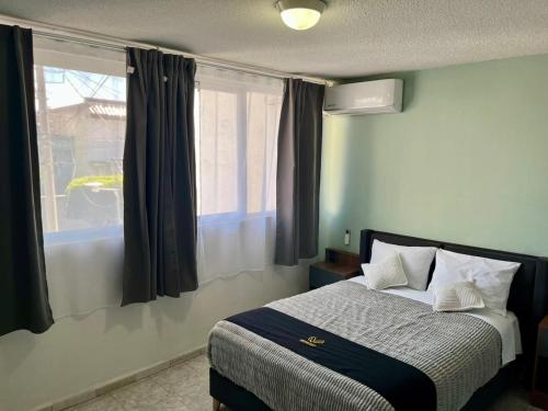 a bedroom with a bed and a window with curtains at 6 VENATOR House Boutique in León