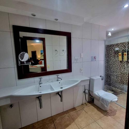 a bathroom with a sink and a toilet and a mirror at IL Nuraghe in Canoa Quebrada
