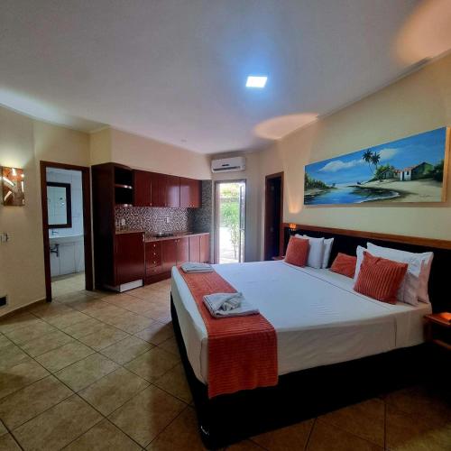 a bedroom with a large bed and a kitchen at IL Nuraghe in Canoa Quebrada