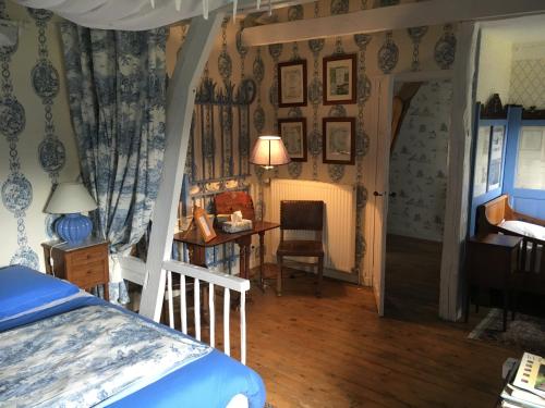 1 dormitorio con cama, escritorio y mesa en Le Prieuré Boutefol, en Surville