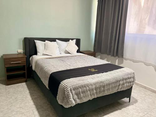 a bedroom with a bed with a black frame and white pillows at 8 VENATOR House Boutique in León