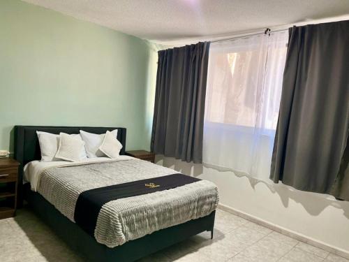 a bedroom with a bed and a large window at 8 VENATOR House Boutique in León