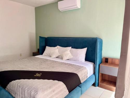 a bed with a blue headboard in a room at 11 VENATOR House Boutique in León