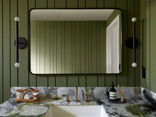 a bathroom with a sink and a mirror at San Luis Creek Lodge in San Luis Obispo