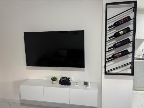 a living room with a white cabinet with wine bottles at Apartman Rose in Čapljina