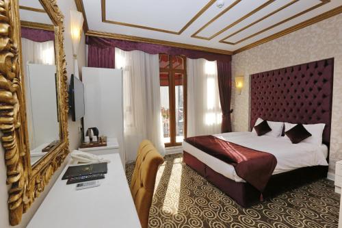 een hotelkamer met een bed en een spiegel bij Diamond Royal Hotel in Istanbul